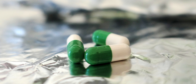 no people, selective focus, pharmacy, drug, plastic, ill, care, container, disease, medical, 5K, green color, encapsulate, drugs, pills, indoors, bottle