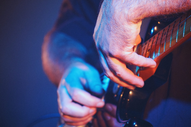 holding, person, human, men, nightlife, night, performance, concert, indoors, man, drink, song, plucking an instrument, banister, leisure activities, sound