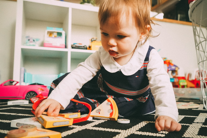 girls, home, finger, one person, child, front view, lifestyles, innocence, cute, indoors, shelf, bookcase, room, wood, holding, offspring, machine, childhood