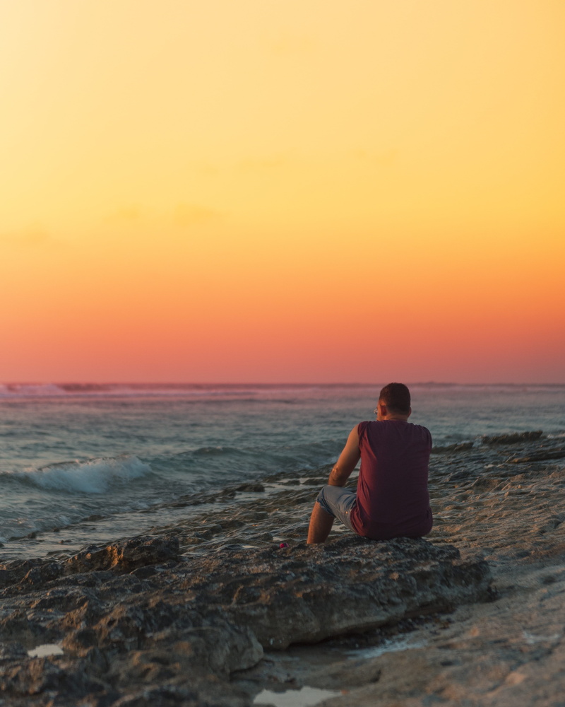 beach, travel, horizon, scenics - nature, horizon over water, addu city, lifestyles, outdoors, sunset, water, one person, rock - object, sitting, hithadhoo