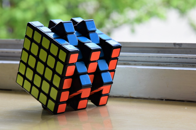 shiny, multi colored, moyu, focus on foreground, indoors, 5x5, cube, block shape, business, rubics, no people, 5K, in a row, hualong, block, magic, group of objects
