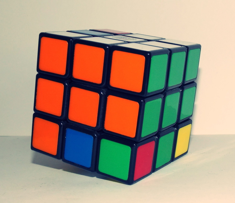 Magic Cube, close-up, single object, toy, block shape, cube, no people, shape, 2K, orange color, color, table, studio shot, multi colored, cube shape