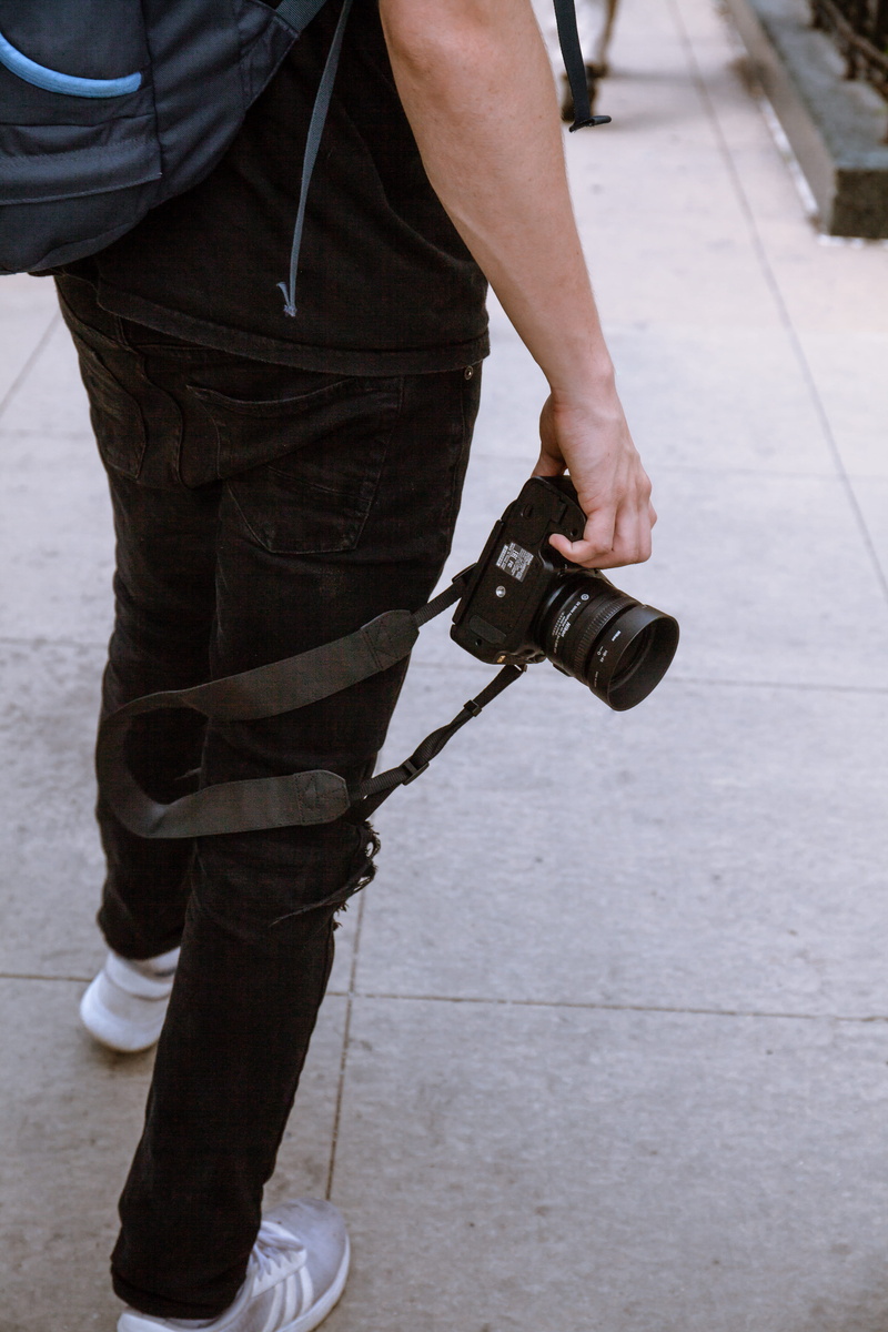 human body part, low section, chicago, black, human leg, lens, people, video camera, human hand, occupation, holding, person, footpath, gear, one person