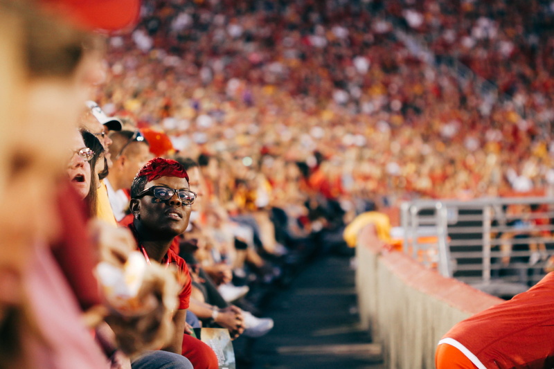 photo, adult, sports, person, selective focus, observe, focus on foreground, crowd, sit, outdoors, men, game, audience, group of people, looking, spectator