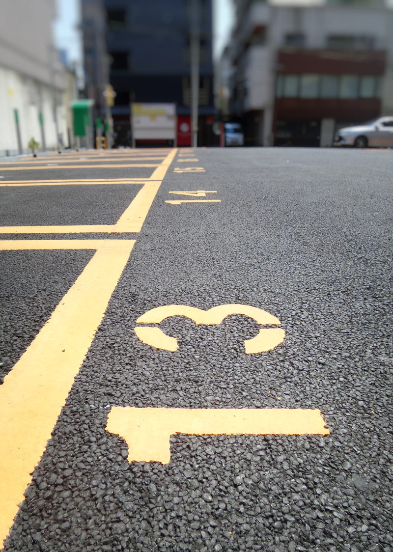 road marking, car park, eye, building, close up, tarmac, communication, sign, worm, parking lot, view, number, city, parking, the way forward, building exterior