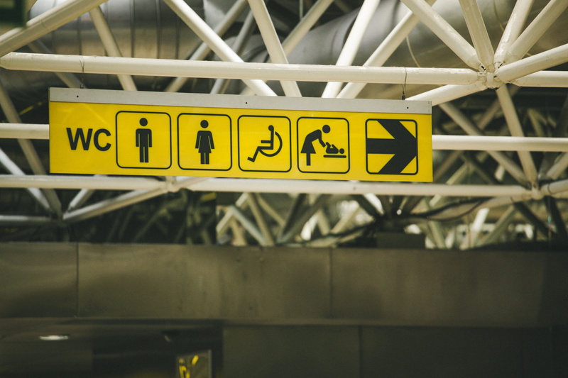 access, western script, airport sign, close-up, ceiling, bathroom, sigange, communication, focus on foreground, symbol, airport, signage, yellow, disability