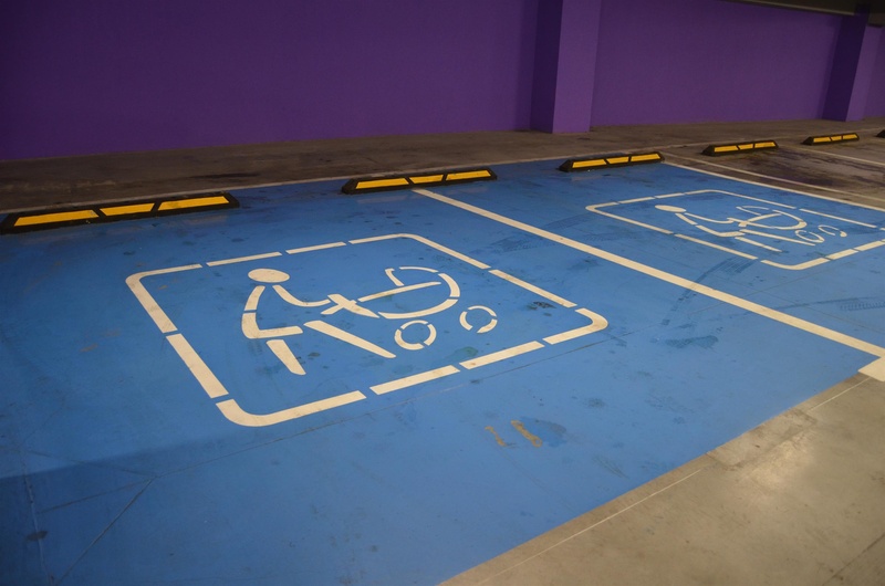 wheelchair, blue, architecture, underground parking, stroller, day, parking sign, parking, parking lot, communication, high angle view, disabled sign, information