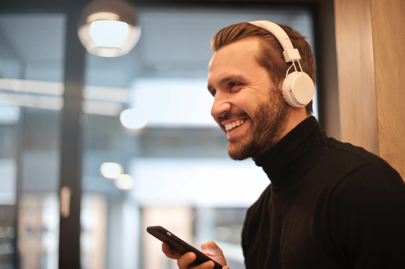 side view, man, music, holding, mobile, male, real people, smile, song, technology, people, outdoors, focus on foreground, beard, office, mobile phone