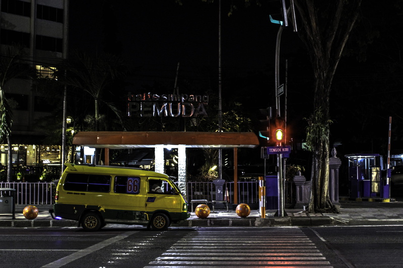 street light, incidental people, city, road, road marking, sign, lighting equipment, building exterior, built structure, architecture, indonesia, motor vehicle