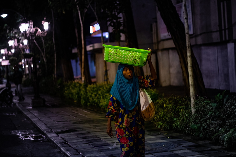 road, sari, focus on foreground, standing, carrying, person, alley, clothing, outdoors, built structure, basket, 5K, architecture, traditional clothing