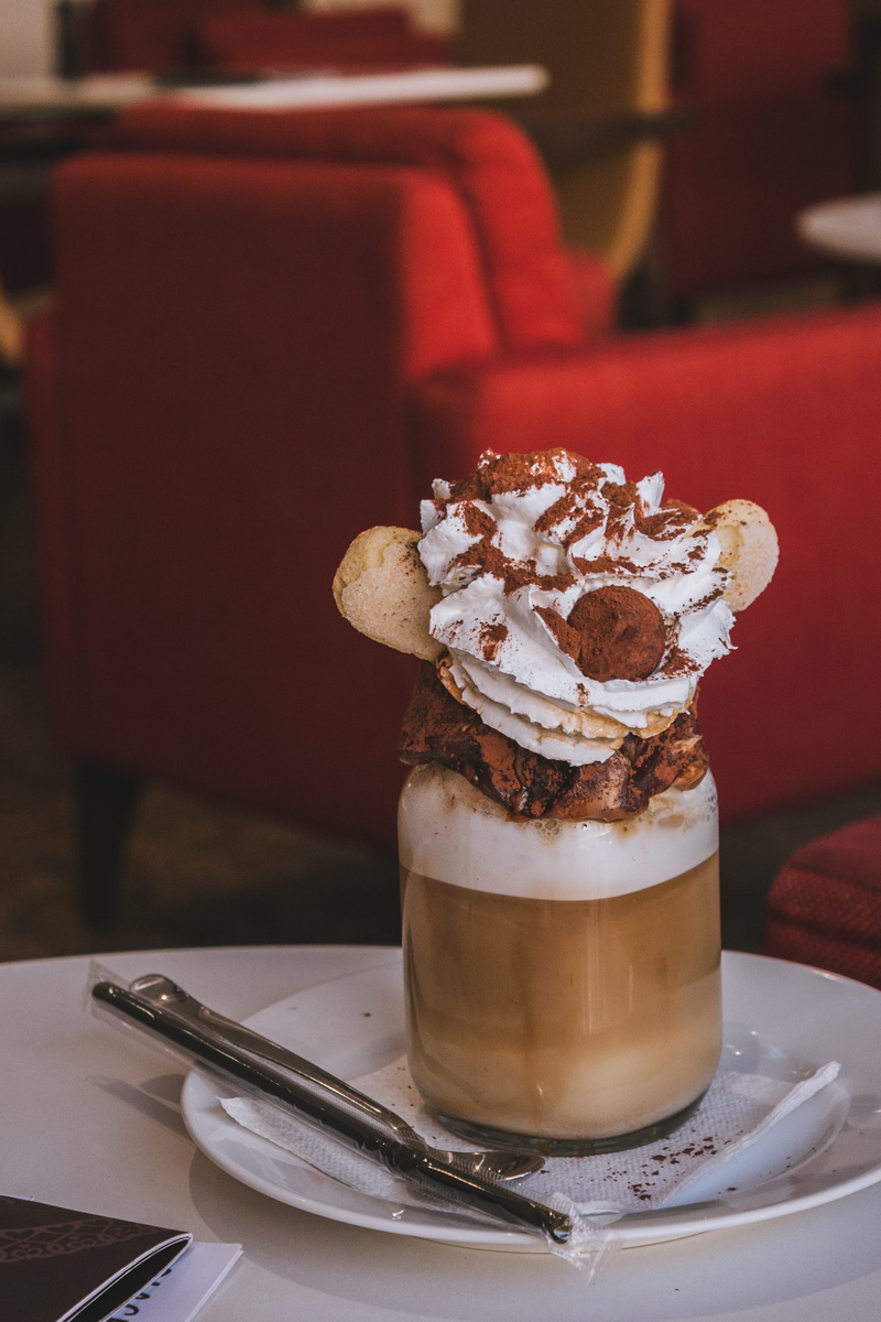 coffee cup, no people, still life, saucer, spoon, business, milk, bread, whipped cream, chocolate, kitchen utensil, 2K, focus on foreground, plate, temptation