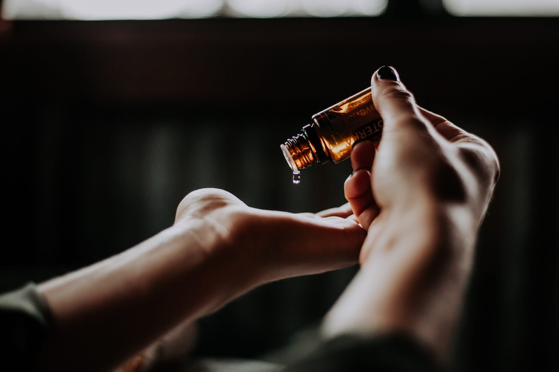 close-up, vial, oils, hand, aromatherapy, holding, indoors, person, human limb, alcohol, amber, refreshment, 5K, pour, focus on foreground, selective focus