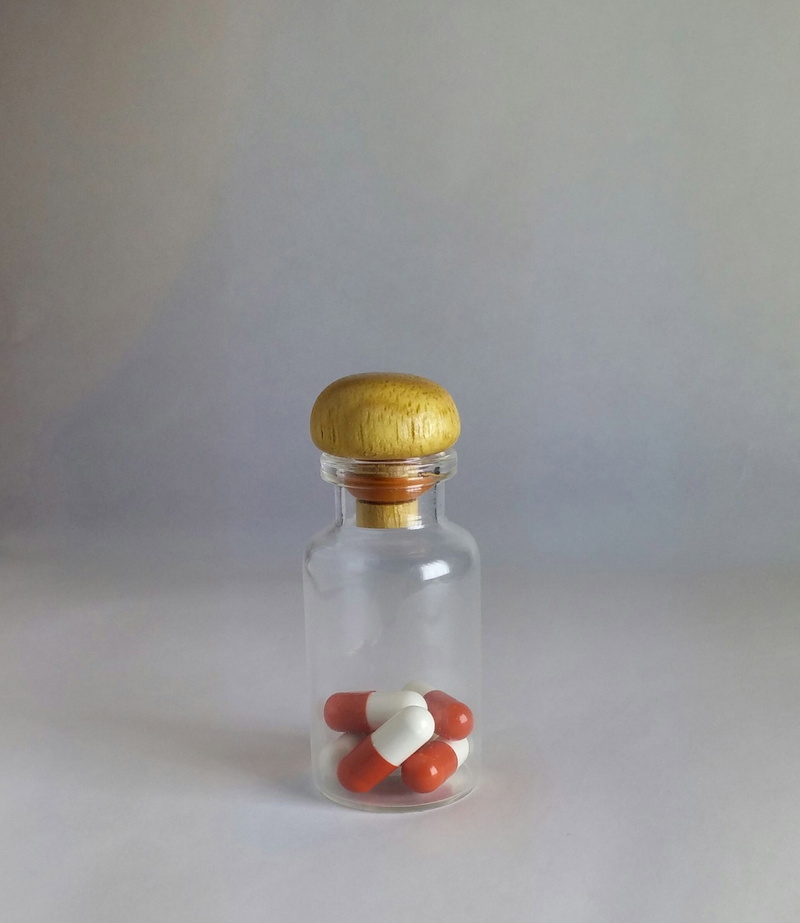 table, wellbeing, pills, no people, indoors, medication, pillbottle, copy space, colored background, gray background, glass - material, healthcare and medicine
