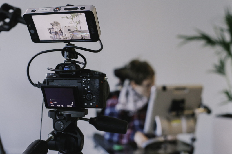 connection, photography themes, computer, table, indoors, real people, filming, black, occupation, focus on foreground, people, home video camera, photographic equipment