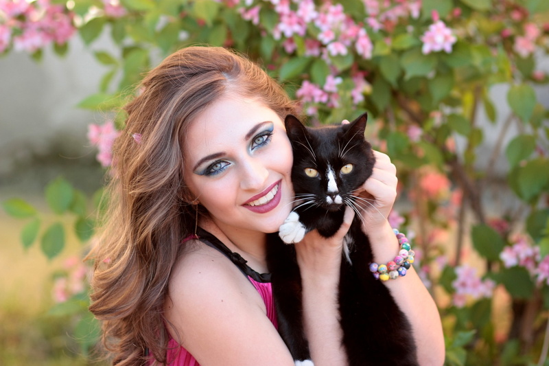 looking at camera, happiness, hug, animal, flowering plant, beautiful, holding, people, woman, smiling, flower, one animal, emotion, teenager, domestic Cat