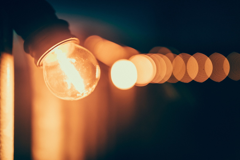 orange color, turned, lamp, blur, night, human body part, electric lamp, brown, bokeh, yellow, focus on foreground, technology, human limb, human hand
