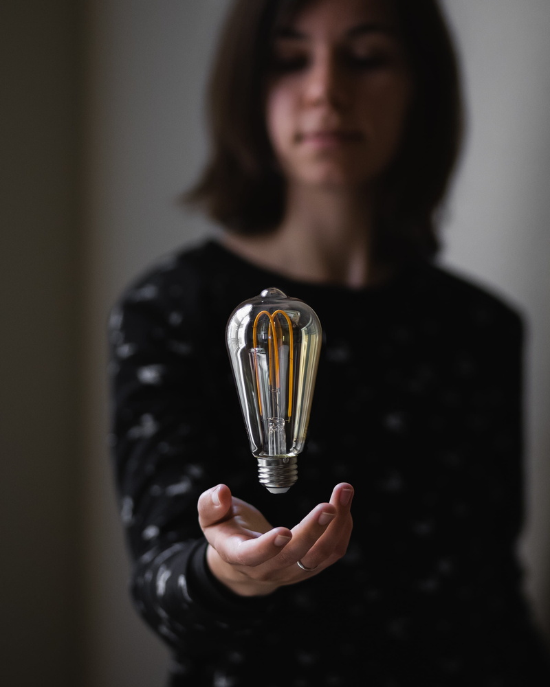 front view, bulb, gray, brunette, young adult, lightbulb, lady, studio shot, female, glass, incandescent, adult, holding, throwing, 2K, human hand, close-up