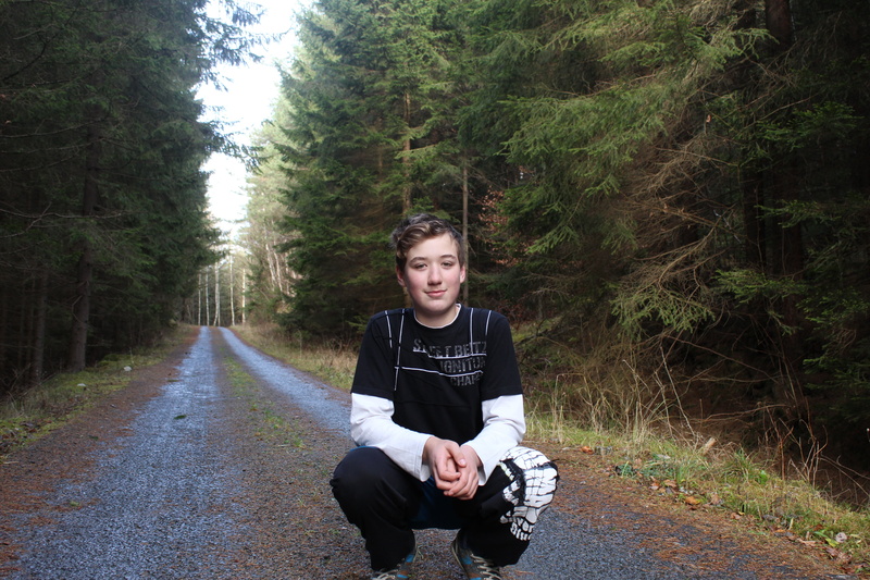 outdoors, casual clothing, one person, walk, trees, direction, teenager, nature, boy, day, tree, front view, young men, friend, 5K, road, sitting, looking at camera