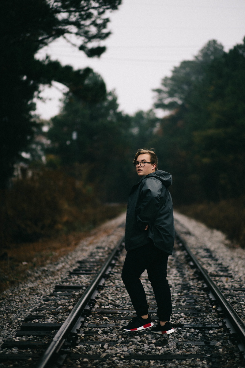 guy, people, railway, plant, rail transportation, direction, tree, lifestyles, looking at camera, leisure activity, one person, nature, day, track, sky