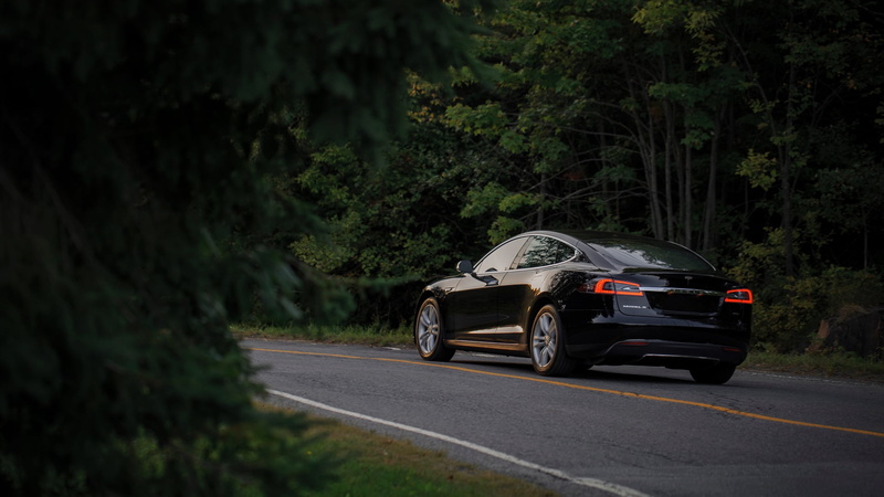 motor vehicle, mode of transportation, outdoors, land vehicle, road, day, plant, land, black cars, trees, no people, transportation, nature, car, sign