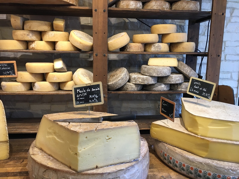 table, indoors, board, shelf, retail display, sale, large group of objects, cheese, container, close-up, retail, wooden, abundance, wood - material, no people