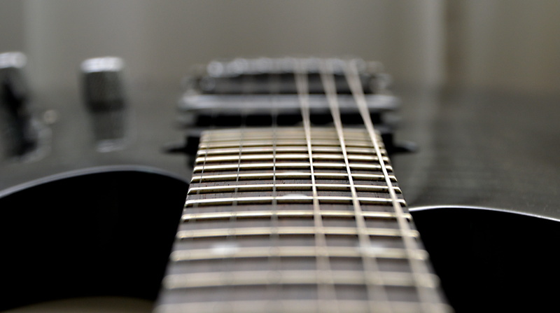 string, bass guitar, close-up, electrically, musical instrument, electric guitar, still life, selective focus, no people, focus on foreground, ibanez, black