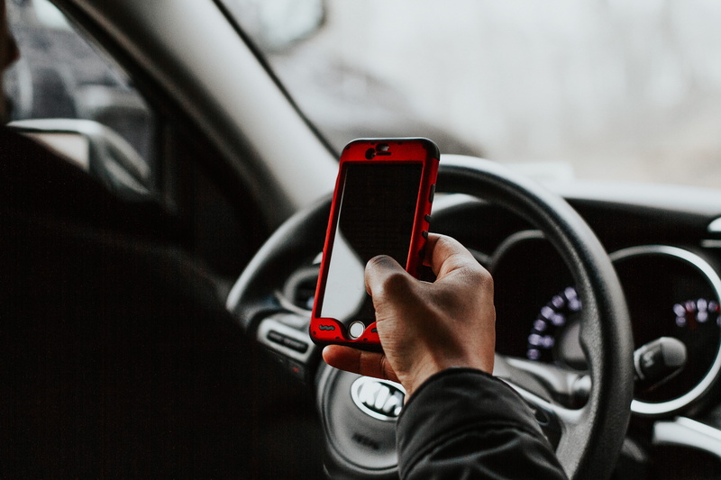 holding, steering wheel, red, front, steering, adult, car, human body part, person, sitting, transportation, windshield, wheel, one person, indoors, mode of transportation