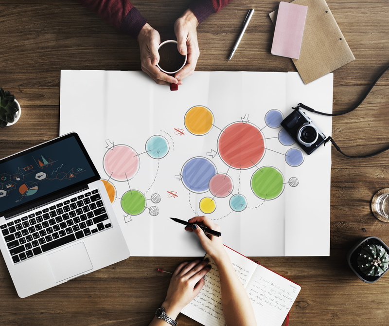 circles, table, indoors, direction, pen, finger, communication, notebook, working, work, adult, human hand, real people, paperwork, colorful, high angle view