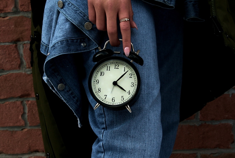 2K, architecture, human body part, clock, brick, casual clothing, focus on foreground, midsection, girl, leisure activity, jeans, real people, standing