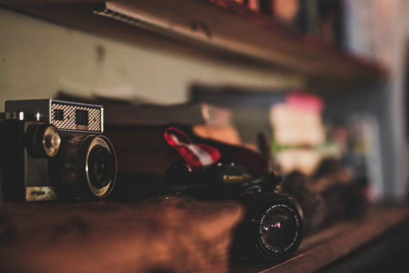 shelf, mode of transportation, black, photographic equipment, car, table, land vehicle, camera - photographic equipment, focus on foreground, retro styled
