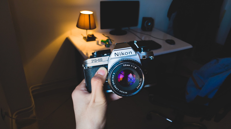 focus on foreground, technology, film, human body part, lens, lens - optical instrument, room, digital camera, person, lifestyles, one person, photographic equipment