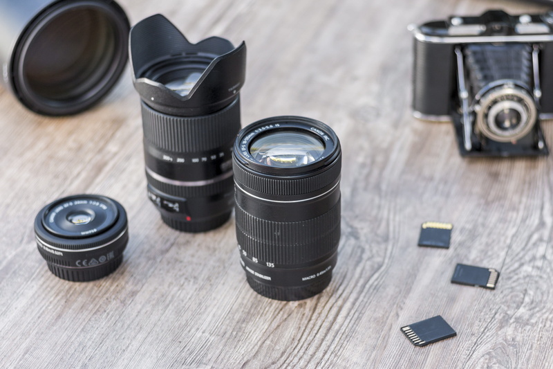 group of objects, high angle view, filming, cameras, photograph, 50mm, close-up, hobby, profession, tripod, table, digital camera, still life, paparazzi