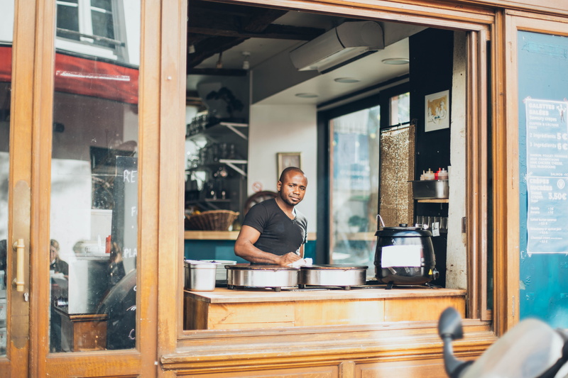 black, near, real people, entrepreneur, men, one person, waist up, cafe, owner, looking at camera, window, wooden, business, small business, shirt, bar