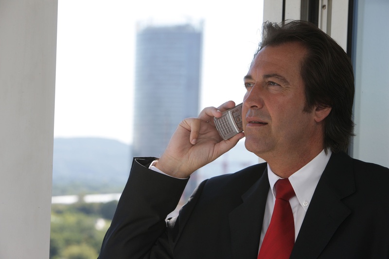 suit, business center, building exterior, business owners, mobile phone, phone, black, mature men, 1080P, outdoors, headshot, businessman, jacket, communication
