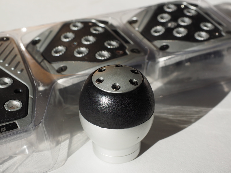 gear shift knob, auto, table, tuning set, salt - seasoning, studio shot, silver colored, no people, single object, pedal pads, black color, indoors, gas pedal kit