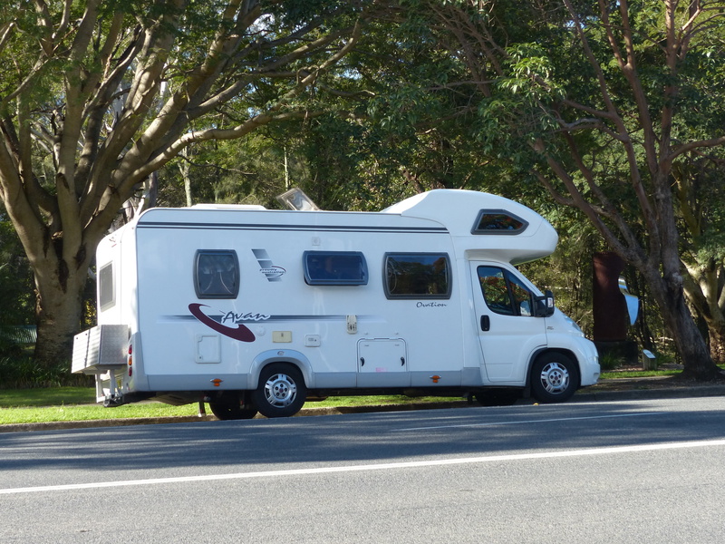 motor vehicle, city, street, outdoors, motorhome, travel, green color, b, beside, camping, no people, side view, stationary, class, nature, car, day, tree