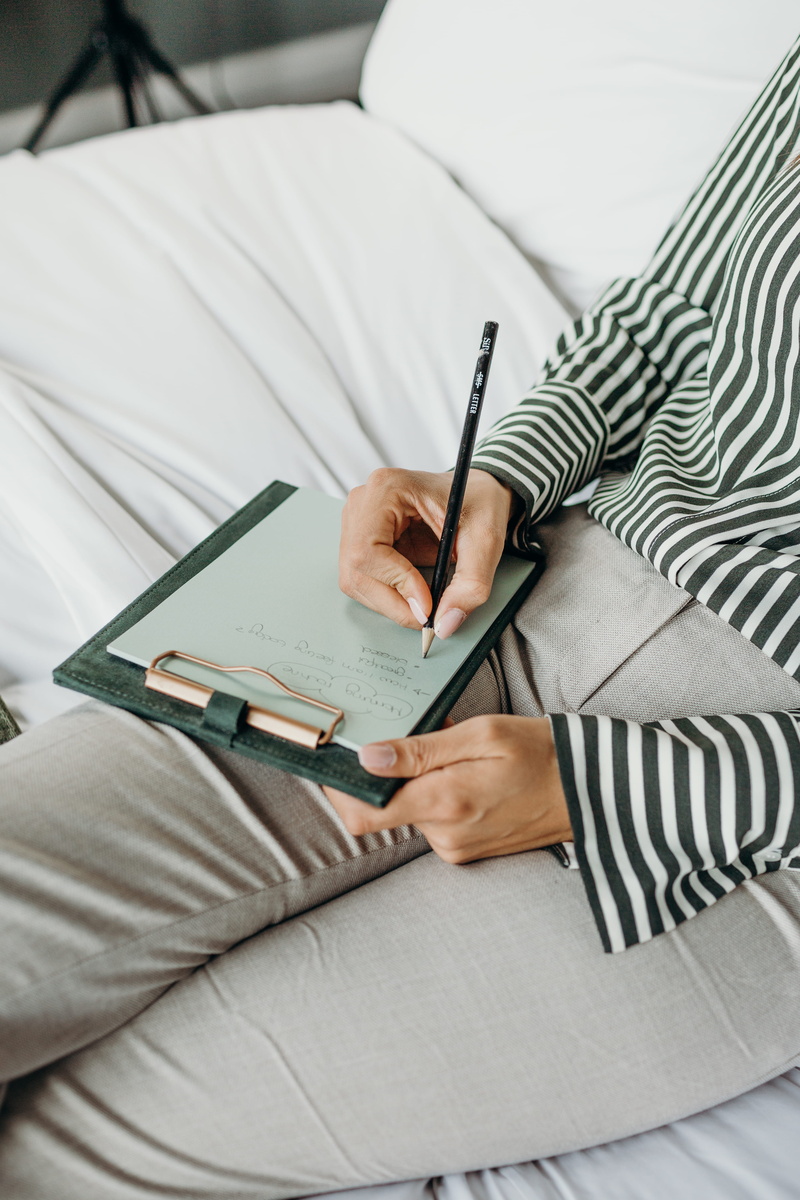 one person, pen, human body part, writing, lifestyles, book, publication, human hand, board, real people, clip, casual clothing, 5K, lap, adult, striped