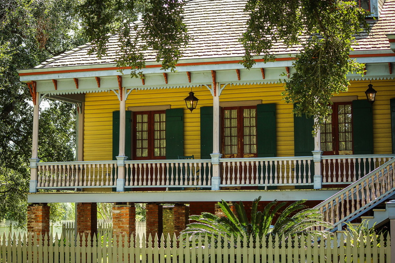 railing, low angle view, plant, yellow, built structure, sunlight, building exterior, new orleans, tree, laura plantation, day, city, fence, front, architecture