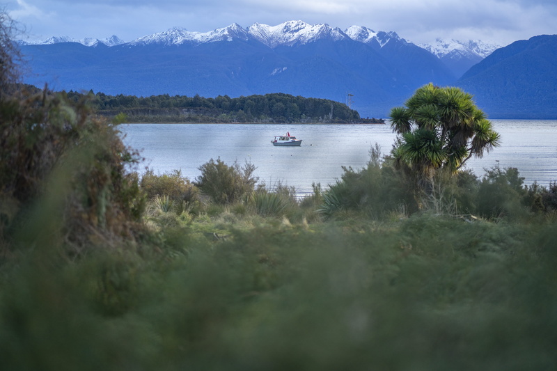 no people, te anau, mountain, tree, scenics - nature, nature, boat, sky, non-urban scene, outdoors, grass, trees, nautical vessel, water, plant, tranquility