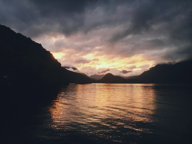 tranquility, beauty in nature, nature, sunset, clouds, cruise, sun, non-urban scene, lake, mountains, mountain, mountain range, lake te anau, sky, boat