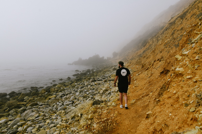 road, rear view, person, dirt road, real people, water, standing, full length, soil, nature, path, ground, rocky, human, leisure activity, shorts, outdoors