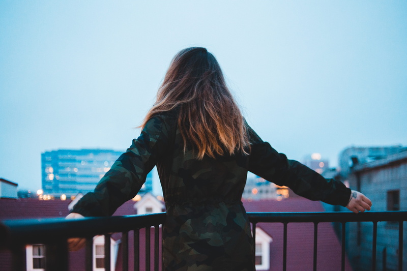 building, standing, lifestyles, clear sky, hairstyle, leisure activity, warm clothing, jacket, pants, rear view, overcoat, clothing, focus on foreground