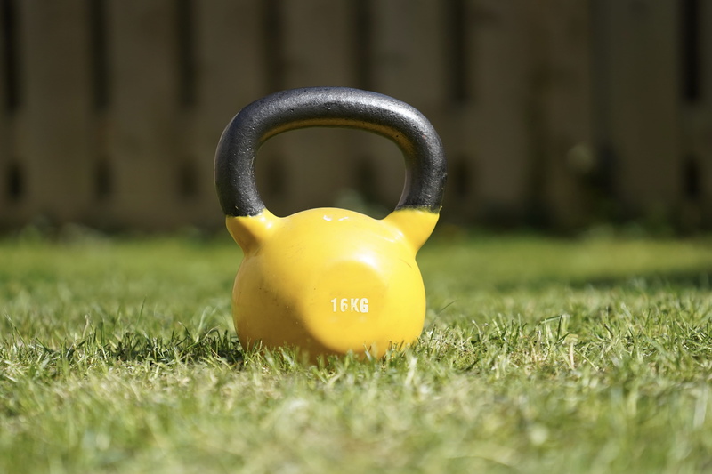 single object, park - man made space, grass, lawn, 5K, yellow, coat, plant, bell, surface level, dumbell, toy, overcoat, day, front or back yard, metal