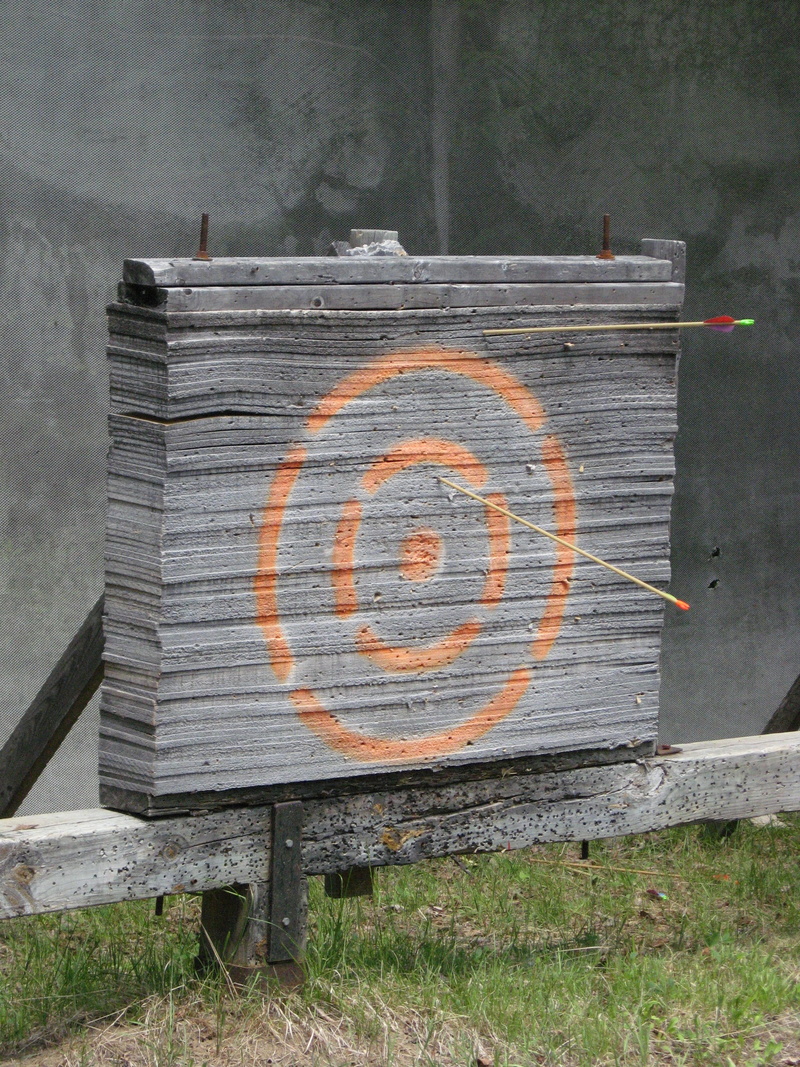 western script, 2K, Bullseye, wall - building feature, bench, Target, Arrow, no people, wood - Material, Aim, warning sign, day, information sign, number