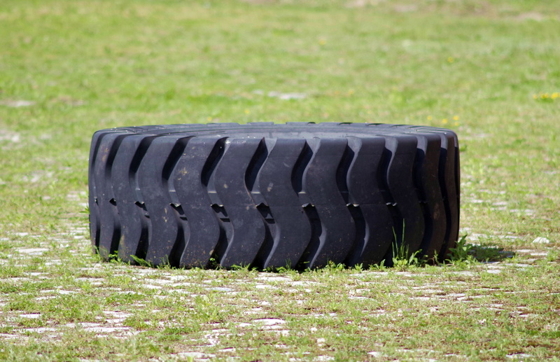 tire, auto parts, focus on foreground, strength exercises, black color, large group of objects, plant, rubber, nature, truck, grass, green color, selective focus