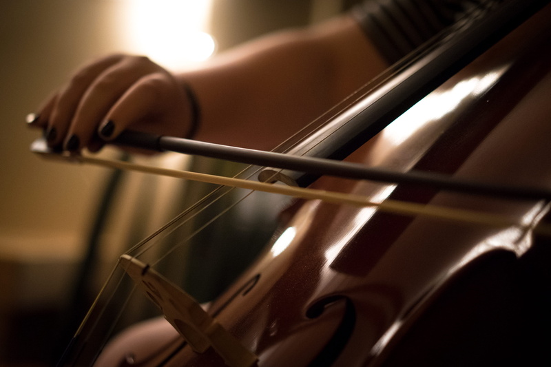 hand, music, art, human body part, close-up, cello, musician, orchestra, indoors, human hand, activity, performance, one person, string instrument, dark room