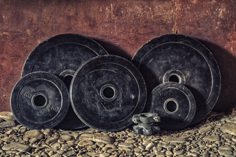 plates, weightlifting, pebbles, geometric shape, no people, dirty, old, steel, strength, weight, weights, rail transportation, circle, abandoned, wheel