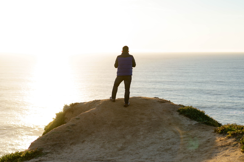 outdoors, horizon, horizon over water, standing, peak, adult, sea, rear view, mountain top, ocean, sunlight, sky, sunset, young adult, lifestyles, beach