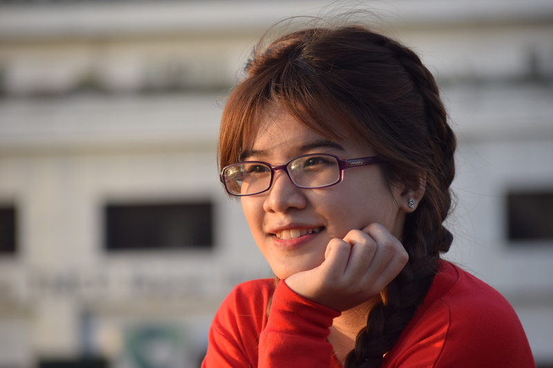 sunny afternoon, adult, architecture, eyeglasses, front view, smile, focus on foreground, child, 5K, headshot, brown hair, glasses, contemplation, beautiful woman