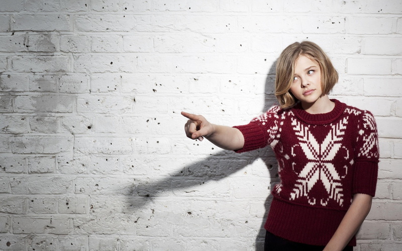 Chloë Grace Moretz, childhood, hairstyle, blond hair, casual clothing, sweater, blonde, brick, waist up, front view, gesturing, human arm, women, innocence